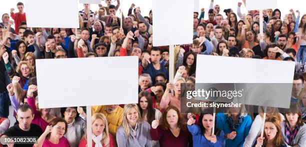 crowd of displeased people holding white banners. - sparse crowd stock pictures, royalty-free photos & images