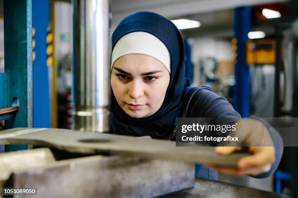 junge frau arbeitet an einem blech stahl in einer hydraulischen presse - maschinenbau stock-fotos und bilder