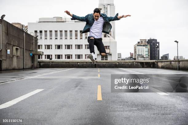 aziatisch mens in stedelijke exploratie op de daken van de stad - free and parking stockfoto's en -beelden