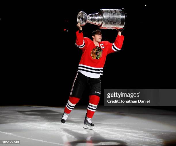 Jonathan Toews of the Chicago Blackhawks carries the Stanley Cup across the ice in a ceremony before the Blackhawks season home opening game against...