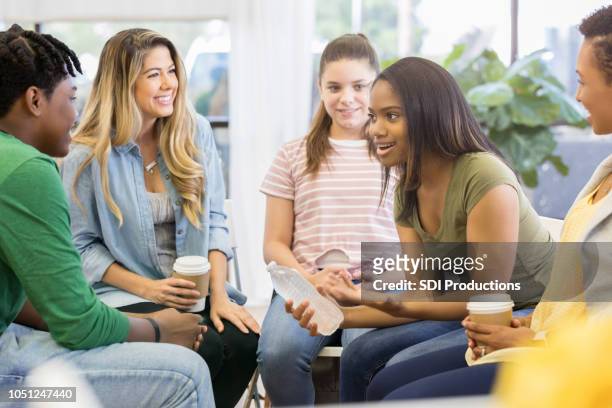 giovane donna usa umorismo quando condivide con il gruppo di supporto - bambini seduti in cerchio foto e immagini stock