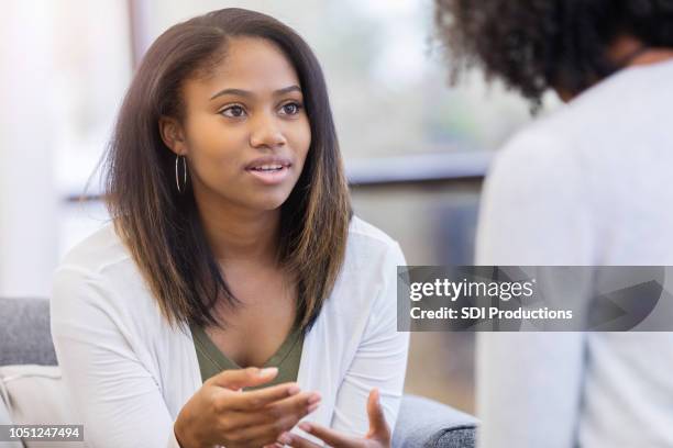 young woman talks to  attentive therapist - teen and doctor stock pictures, royalty-free photos & images