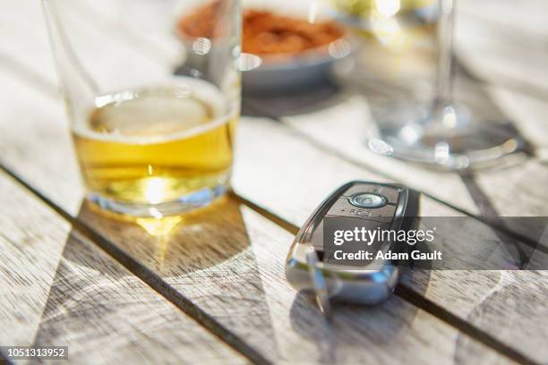 drink driving car key and glass of beer - car keys table stock-fotos und bilder