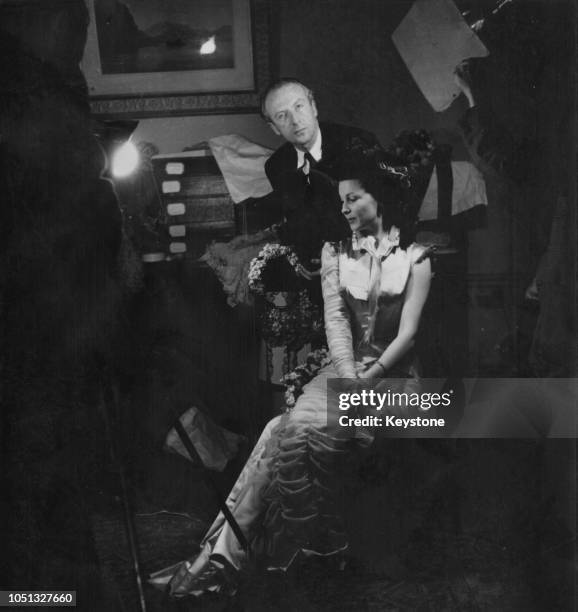 English actress Vivien Leigh trying on an outfit for her title role in 'Anna Karenina', directed by Julien Duvivier, with costume designer Cecil...