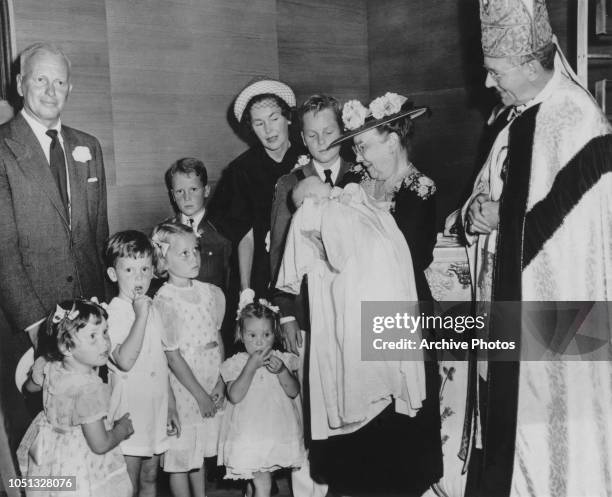 American filmmaker John Farrow with his wife, actress Maureen O'Sullivan and their children at the baptism of baby Teresa Farrow, USA, 1951. Holding...