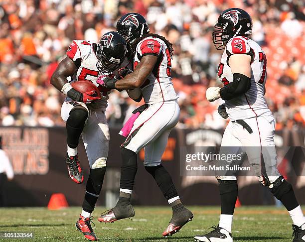 Linebacker Stephen Nicholas of the Atlanta Falcons celebrates with Curtis Lofton and Sam Baker after intercepting the ball against the Cleveland...