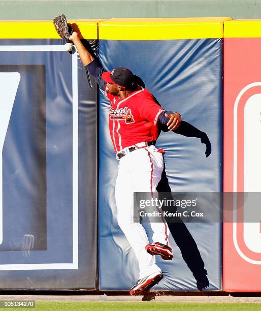 Jason Heyward of the Atlanta Braves collides with the wall as he misplays a fly ball hit by Mike Fontenot of the San Francisco Giants during Game...