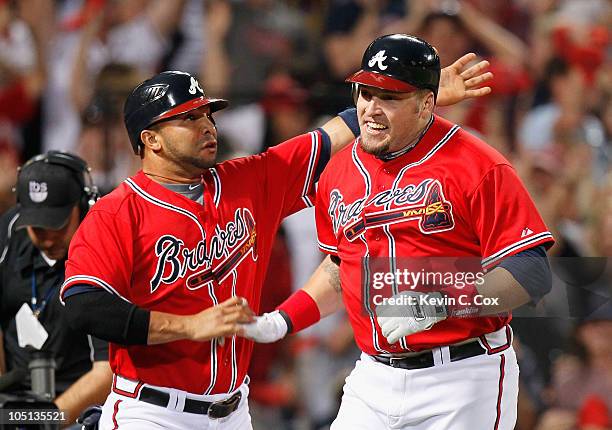 Eric Hinske of the Atlanta Braves reacts with Alex Gonzalez after Hinske hit a two-run homer in the eighth inning off pitcher Sergio Romo of the San...