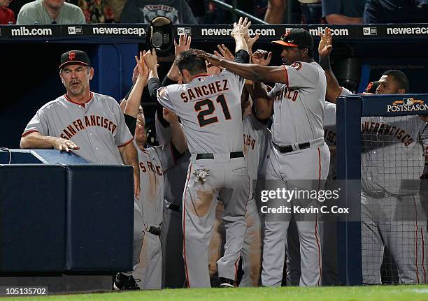 Freddy Sanchez of the San Francisco Giants celebrates after scoring the go-ahead run off an error by Brooks Conrad of the Atlanta Braves in the ninth...