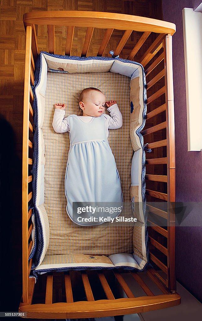 Baby boy sleeping peacefully in crib