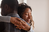 Close up black African wife embracing husband
