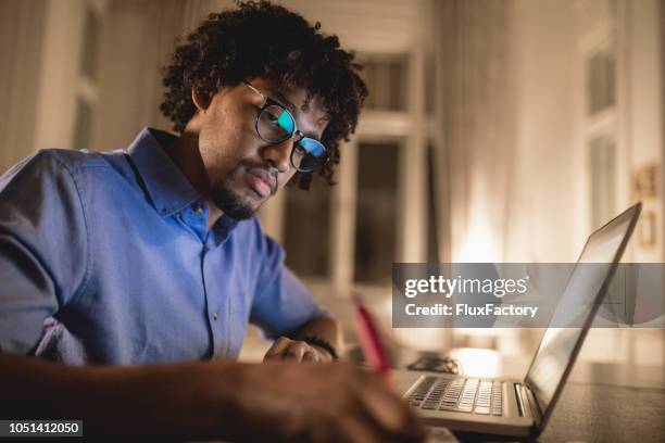 estudiante escribir un ensayo la noche antes del examen - elearning man fotografías e imágenes de stock