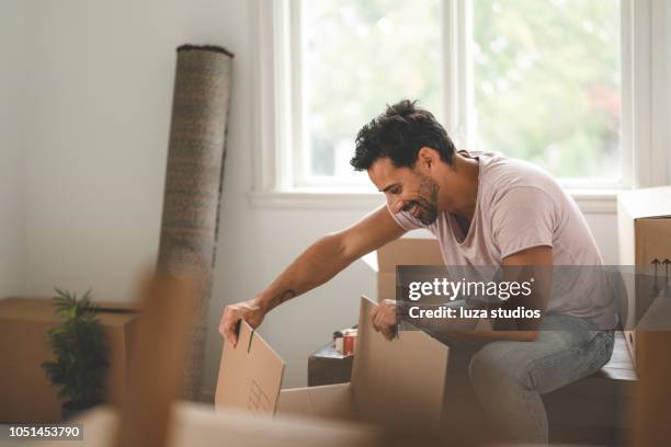 man moving into a new house - desempacotar imagens e fotografias de stock