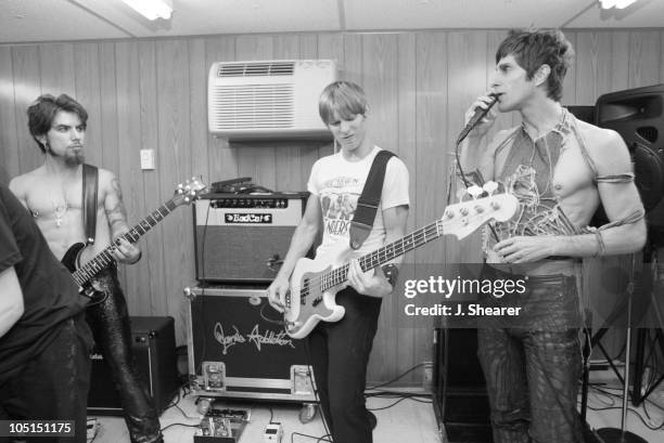 Dave Navarro, Chris Chaney and Perry Farrell of Jane's Addiction rehearse in their tuning room backstage.