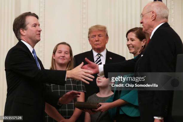 Supreme Court Associate Justice Brett Kavanaugh shakes hands with retired Justice Anthony Kennedy after Kavanaugh's ceremonial swearing in with his...