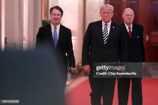 Supreme Court Justice Brett Kavanaugh, President Donald Trump and retired Justice Anthony Kennedy walk into the East Room of the White House for...