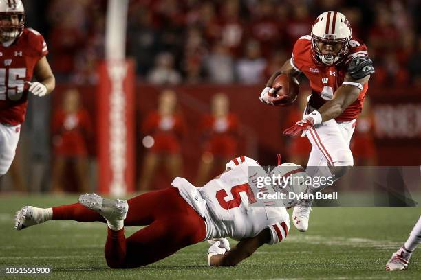 Taylor of the Wisconsin Badgers runs with the ball while being tackled by Dedrick Young II of the Nebraska Cornhuskers in the second quarter at Camp...