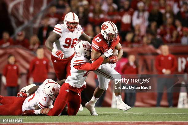 Jonathan Taylor of the Wisconsin Badgers runs with the ball while being tackled by Antonio Reed of the Nebraska Cornhuskers in the third quarter at...