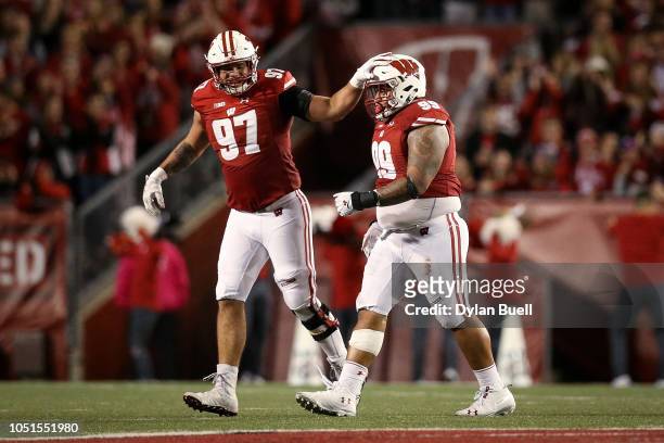Isaiahh Loudermilk and Olive Sagapolu of the Wisconsin Badgers celebrate after recovering a fumble in the third quarter against the Nebraska...