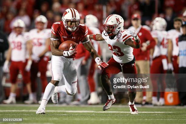 Taylor of the Wisconsin Badgers runs with the ball while being chased by Dicaprio Bootle of the Nebraska Cornhuskers in the third quarter at Camp...