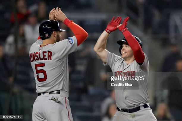 Brock Holt of the Boston Red Sox celebrates with teammate Ian Kinsler after hitting a two run home run against Austin Romine of the New York Yankees...
