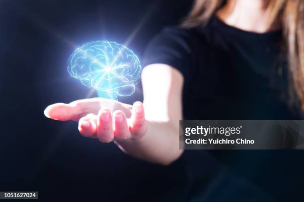 woman showing the brain hologram - brain hand stock-fotos und bilder