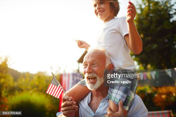 multi-generation family celebrating 4th of july - holding flag stock pictures, royalty-free photos & images
