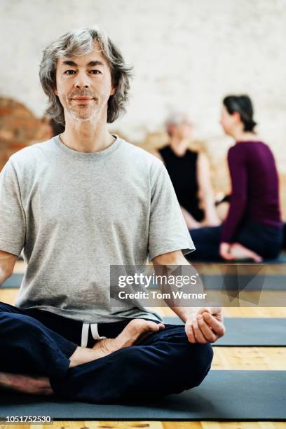 mature man sitting in lotus position - amateur photography stock pictures, royalty-free photos & images