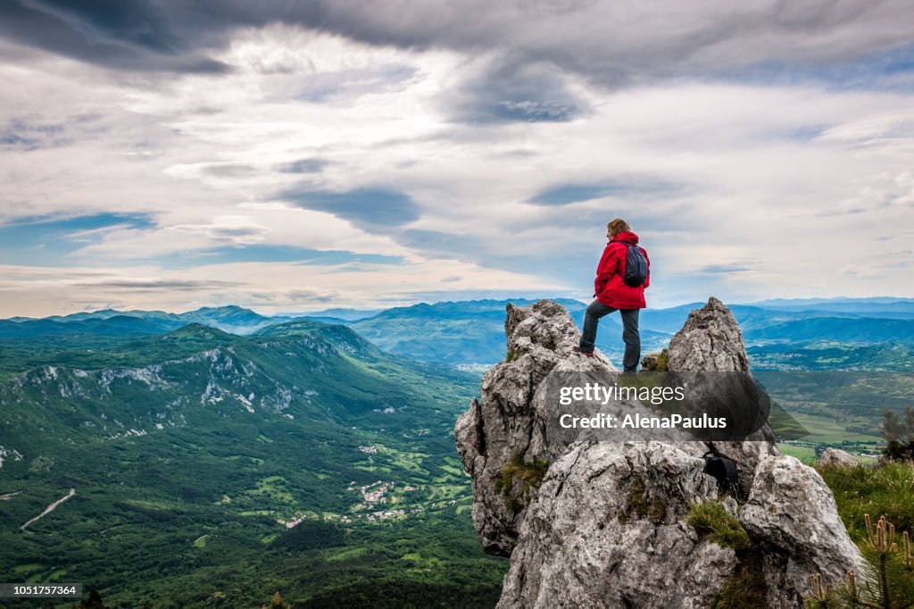 Senior Woman genießen die erstaunliche Landschaft hoch in die Berge