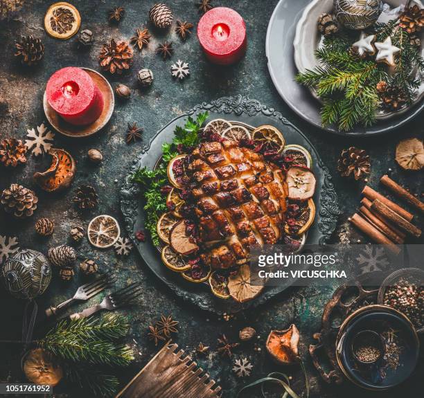 christmas dinner table with roasted pork ham , flavors, decoration and candles - food table stock pictures, royalty-free photos & images