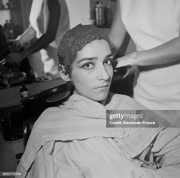 Une femme, les cheveux enduit de boue à l'institut capillaire Carita, à Paris, France, le 24 février 1967.