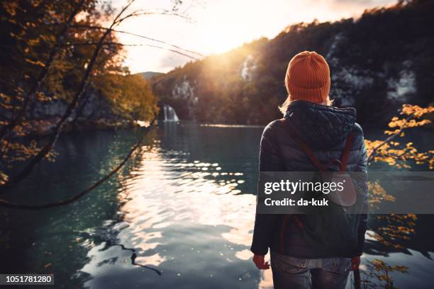 turístico, explorando el parque nacional de plitvice - mujer de espaldas en paisaje fotografías e imágenes de stock