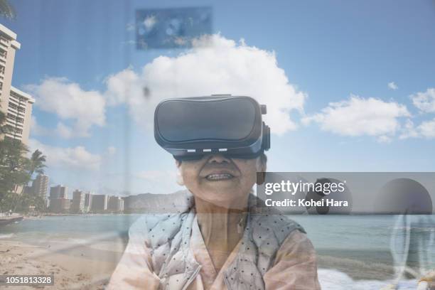 senior woman in the hospital wearing a virtual reality headset - virtual vacations stock pictures, royalty-free photos & images
