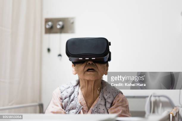 senior woman in the hospital wearing a virtual reality headset - finding hope stock pictures, royalty-free photos & images