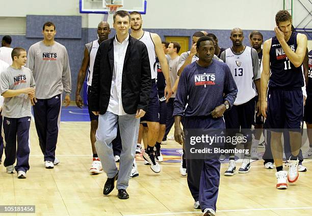 Russian billionaire Mikhail Prokhorov, third left, walks on court with his New Jersey Nets players after meeting them before a basketball show at the...