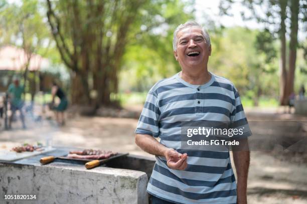 senior man at barbecue party - portrait - latin american and hispanic ethnicity picnic stock pictures, royalty-free photos & images