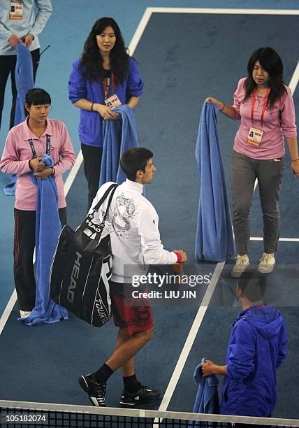 Novak Djokovic of Serbia leaves the court after heavy rain delayed the start of the finals in Beijing on October 10, 2010. Heavy rain has delayed the...