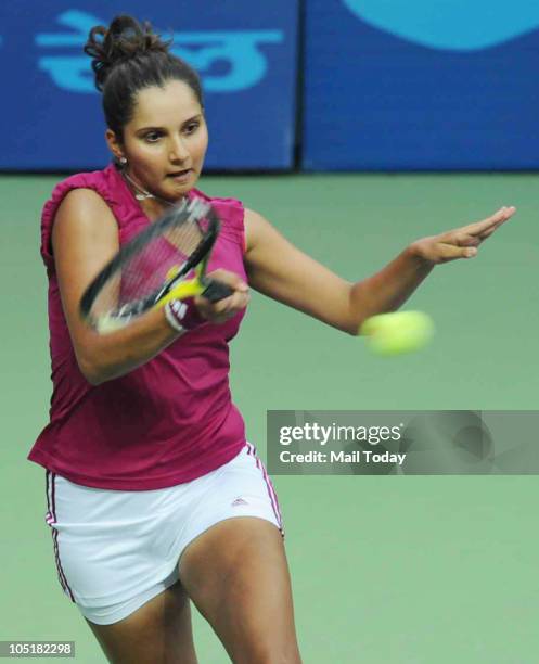 Indian Sania Mirza hits a shot against Australian Anastasia Rodionova in the Tennis Women's Singles during the Commonwealth Games at the R.K. Khanna...