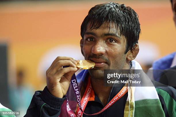 India's Yogeshwar Dutt kisses his gold medal after beating Canada's James Mancini to win gold in the 60kg freestyle category during the Commonwealth...