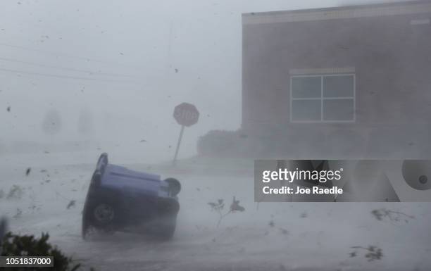 Trash can and debris are blown down a street by Hurricane Michael on October 10, 2018 in Panama City, Florida. The hurricane made landfall on the...