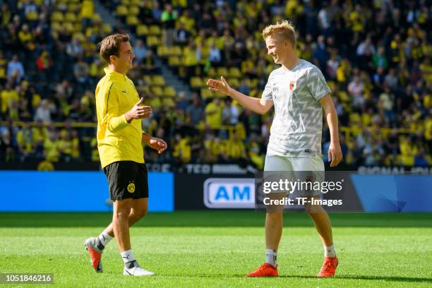 Mario Goetze of Borussia Dortmund and his brother Felix Goetze of FC Augsburg slap hands during the Bundesliga match between Borussia Dortmund and FC...