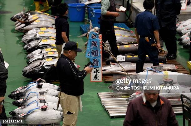 Buyers, workers and auctioneers attend the first tuna auction at the new Toyosu fish market, the first day of the market's opening in Tokyo on...