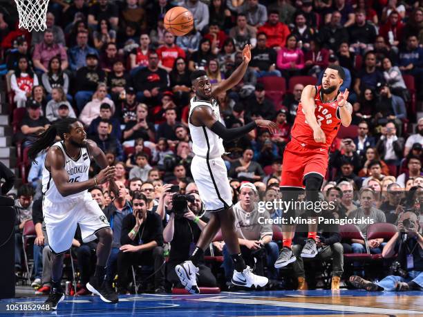 Fred VanVleet of the Toronto Raptors plays the ball past Caris LeVert and Kenneth Faried of the Brooklyn Nets during the preseason NBA game at the...