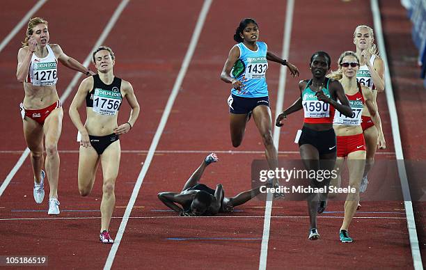 Winny Chebet of Kenya falls as Nancy Lan'gat of Kenya races to the finish line to claim gold in front of silver medalist Nikki Hamblin of New Zealand...