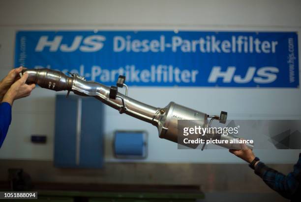 October 2018, North Rhine-Westphalia, Menden: An employee is working on an SCR catalytic converter for retrofitting diesel for nitrogen reduction at...