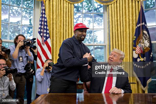 Rapper Kanye West, left, shakes hands with U.S. President Donald Trump during a meeting in the Oval Office of the White House in Washington, D.C.,...