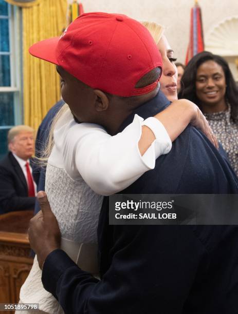 Rapper Kanye West hugs Ivanka Trump after meeting with US President Donald Trump in the Oval Office of the White House in Washington, DC, on October...