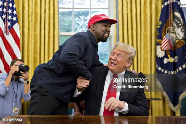 Rapper Kanye West, left, shakes hands with U.S. President Donald Trump during a meeting in the Oval Office of the White House in Washington, D.C.,...
