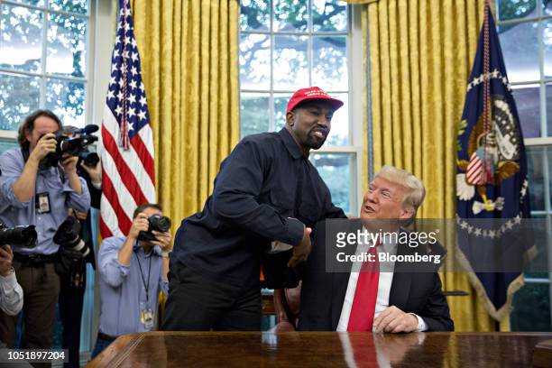 Rapper Kanye West, left, shakes hands with U.S. President Donald Trump during a meeting in the Oval Office of the White House in Washington, D.C.,...