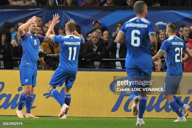 Iceland's midfielder Birkir Bjarnason celebrates with teammates after scoring a goal during the friendly football match between France and Iceland at...